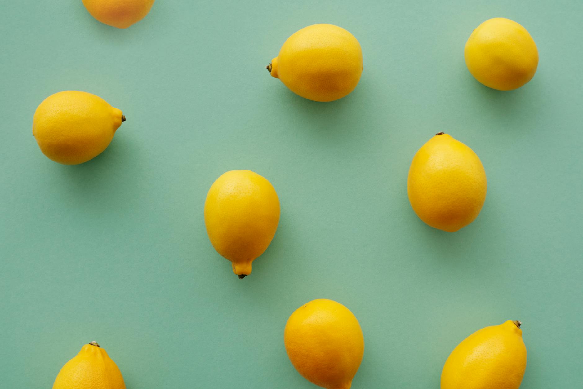 Bright yellow lemons arranged on a pastel green background, symbolizing a fresh start with lemon vibrators