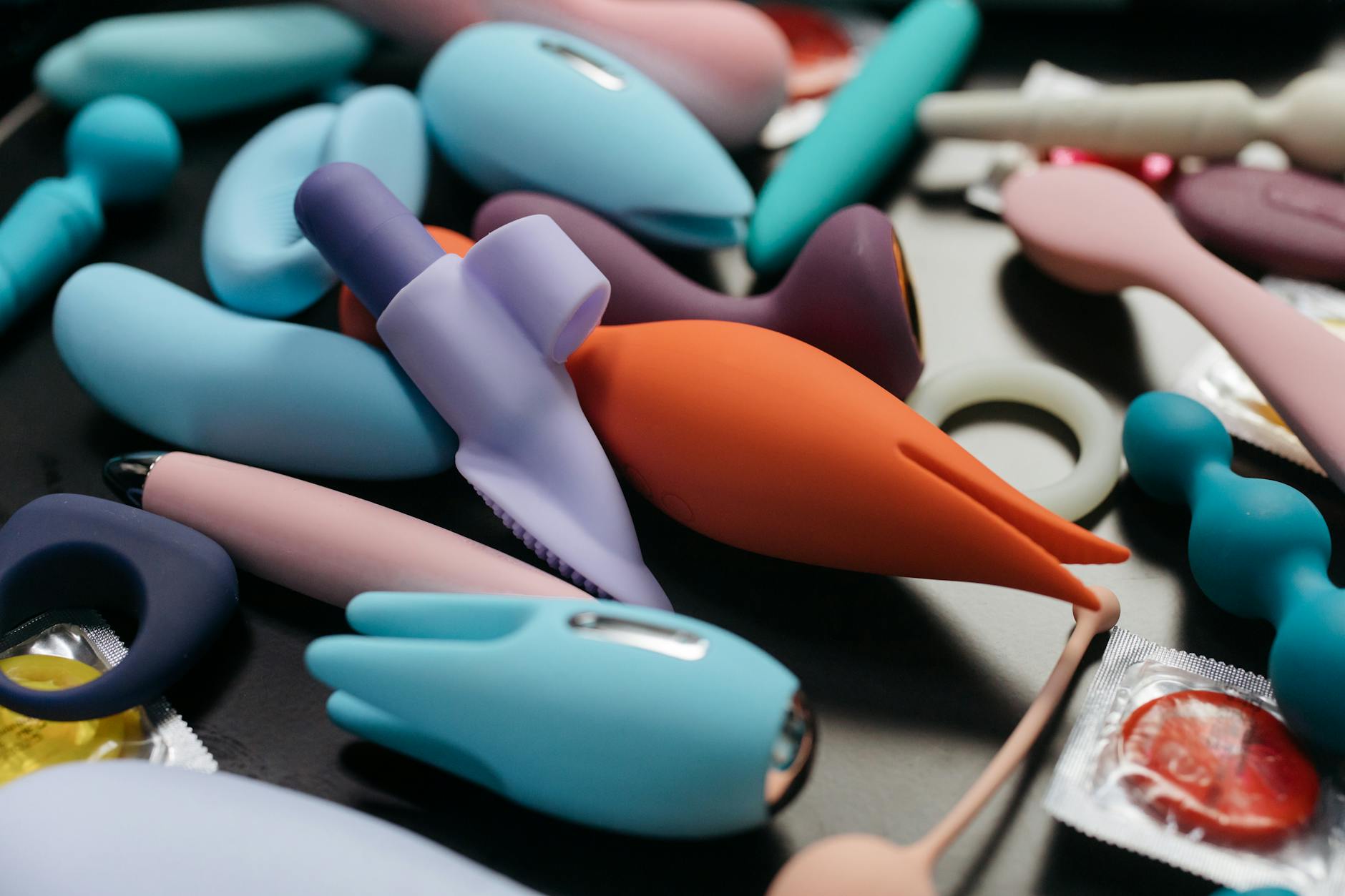 A vibrator held in hand against a purple background, representing self-pleasure and partnered intimacy