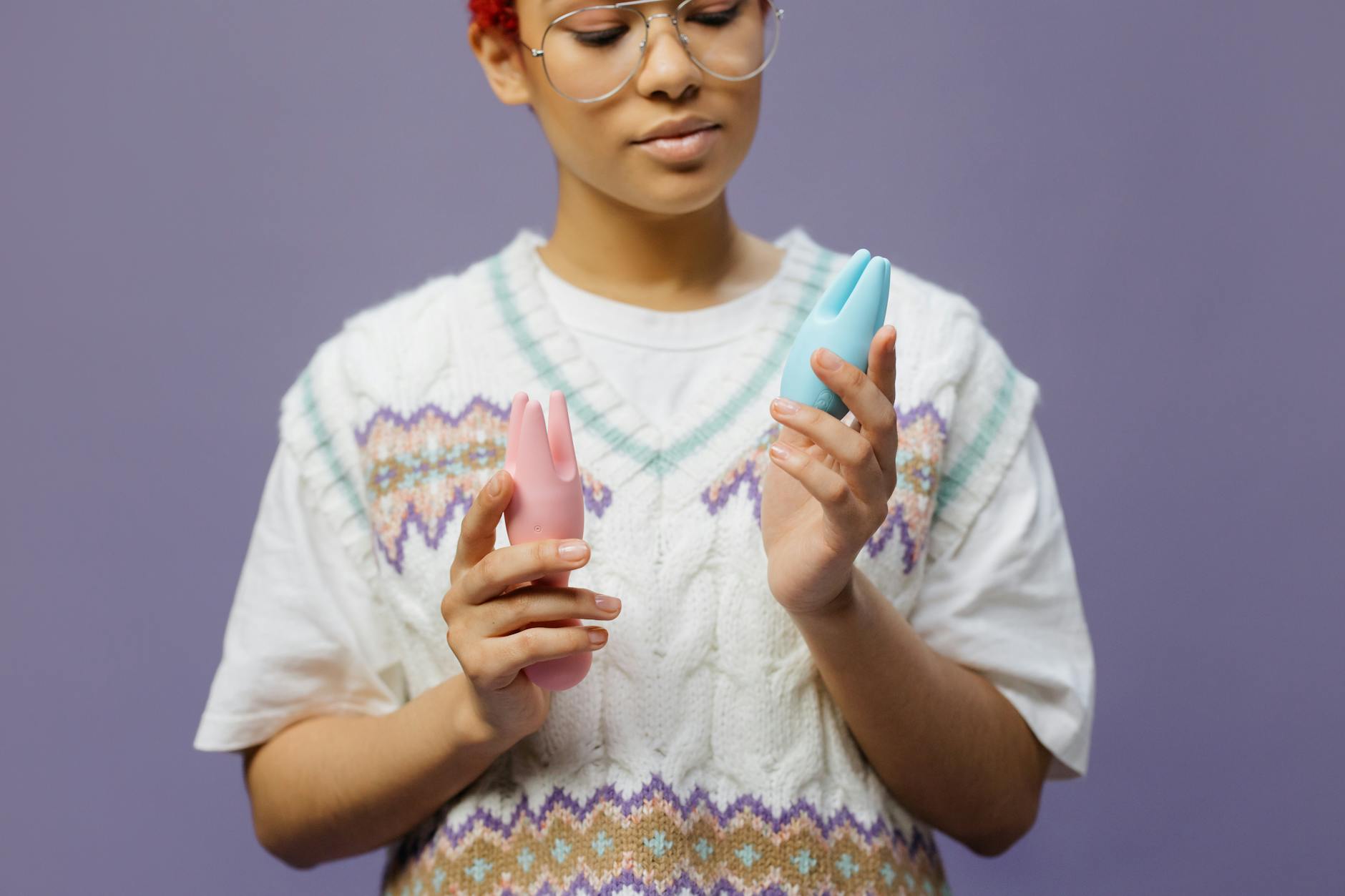 Woman holding colorful silicone vibrators, representing personal pleasure and intimate wellness tools